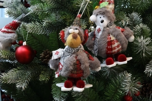 Detail of Christmas reindeer and polar bear plush dolls with red plaid caps on a tree