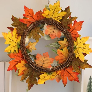 Detailed close-up of Halloween pumpkin wreath with maple leaves on a rustic rattan base