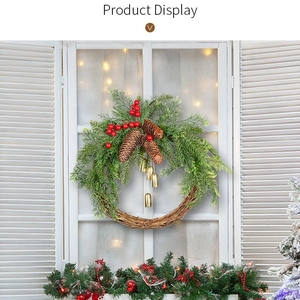 Christmas wreath with pine cones red berries and gold bells on white wood window