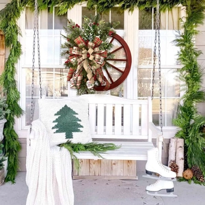 Christmas rustic wagon wheel wreath with pine cones, red berries and holiday bow