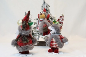 Close-up of three Christmas plush dolls in red plaid outfits with snowflake bases