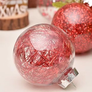 Macro shot of clear PET Christmas ball with red silk filler and silver embossed metal cap