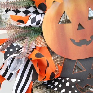 Ghirlanda di zucca di Halloween con nastri neri e arancioni e foglie autunnali