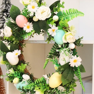 Easter wreath with faux roses, daisies, and colorful eggs on a rustic vine base