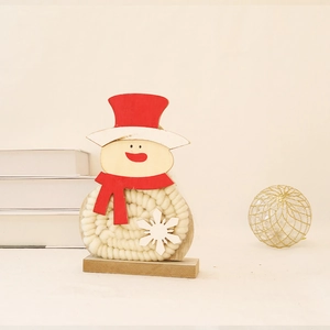 Detail of wooden snowman ornament with red hat and white wool yarn texture on base