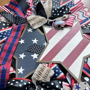 Close-up of patriotic wooden stars and layered patterned ribbons on a 45cm floral wreath