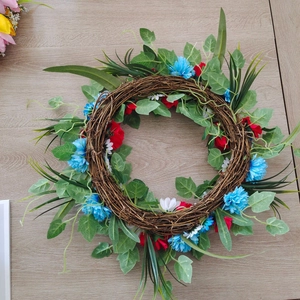 Close-up of patriotic wreath with red white and blue flowers on natural vine base
