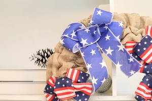 Detailed close-up of burlap texture and star-patterned ribbons on patriotic wreath