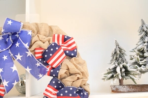 Detail of burlap wreath featuring patriotic American flag ribbon with stars and stripes