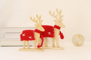 Close-up of wooden reindeer figures with red wool felt blankets and festive snowflake embroidery