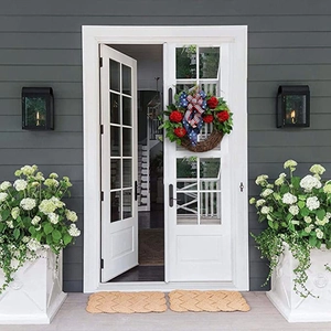 Patriotic 4th of July wreath with red flowers and star bow on white front door