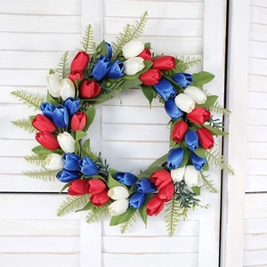Patriotic red white and blue tulip wreath for front door decor on white wood background