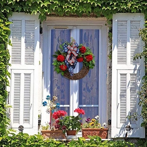 Patriotic July 4th floral wreath with American flag bow on white wooden background