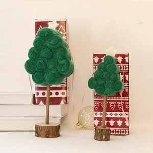 Handmade wool felt Christmas tree decorations on rustic wood bases for holiday tabletop