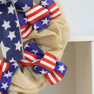 Close-up of July 4th burlap wreath featuring US flag stars and stripes ribbon detail