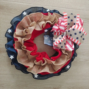 Detail of burlap Independence Day wreath with patriotic ribbon and star pattern bow