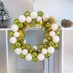Detail of Christmas wreath with shiny green balls white matte spheres and gold stars