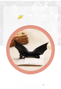 Detailed view of black faux leather bat hair clips with metal duckbill clips on display card