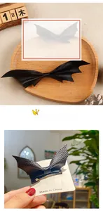 Detail view of black faux leather bat hair clip with textured wings and bow finish