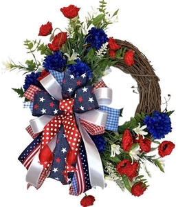 Independence Day wreath with red poppies, blue flowers, and striped bow on vine base