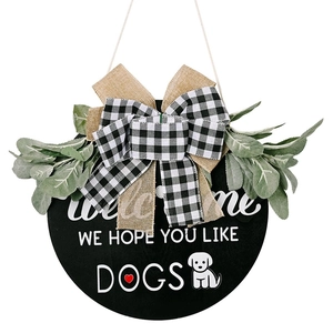 Welcome wooden door sign featuring green leaves, plaid bow, and dog paw prints design