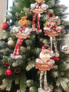 Close-up of four festive Santa and snowman hanging ornaments with Feliz Navidad wooden signs
