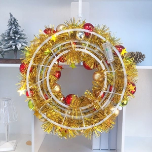 Christmas wreath with red, gold, green balls and gold star on a festive table setting