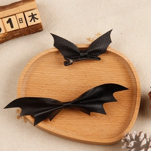 Halloween black leather bat wing hair clips set on a decorative wooden tray