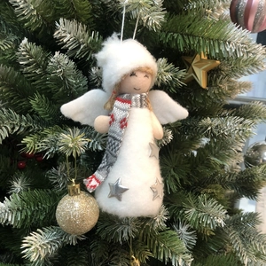 Christmas angel doll ornament with white plush fur and wings hanging on a green tree