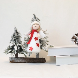 Macro shot of a plush white Christmas angel ornament with red scarf and star detail