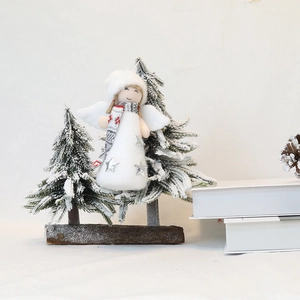 Detailed Christmas angel doll with plush wings and snowy pine trees on a wooden base