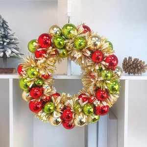 Close-up of a festive Christmas wreath with red, green and gold metallic ornaments