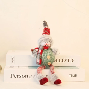 Close-up of a knitted Christmas elf doll with striped scarf and wooden button details