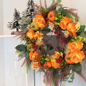 Autumn wreath with orange roses, pumpkins, and berries for rustic farmhouse home decoration