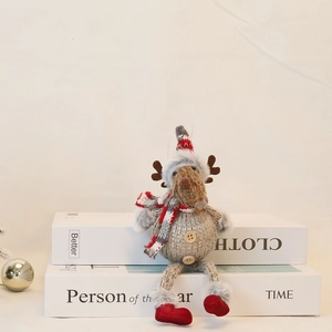 Detail of a knitted reindeer plush ornament with a festive scarf and wooden buttons