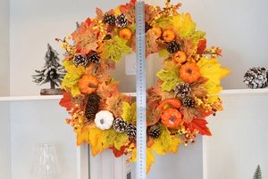 Close-up of fall pumpkin wreath featuring maple leaves and pinecones measuring 50cm