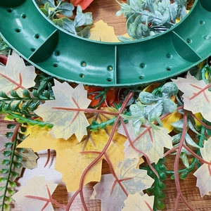 Detail of fall sunflower wreath showing realistic foliage and back support frame