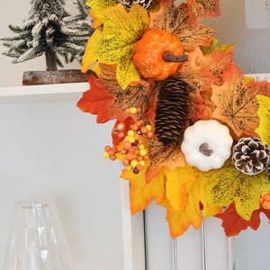 Autumn wreath with maple leaves, pumpkins and pine cones for Thanksgiving home decoration