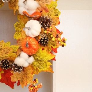 Détail d'une couronne d'automne avec feuilles d'érable, coton et mini citrouilles