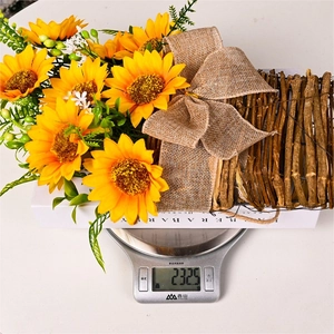 Artificial sunflower hanging basket with yellow flowers and green leaves on a white gift box