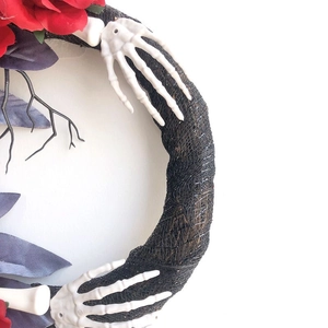 Halloween wreath with black branches, red roses, and white skeleton hands for door decor
