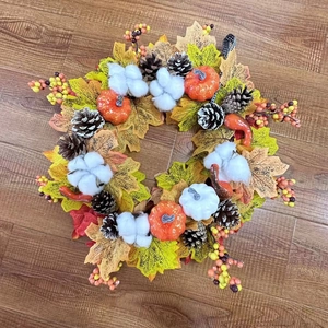 Détail d'une couronne d'automne avec feuilles d'érable, pommes de pin et citrouilles