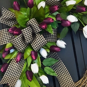 Faux tulip wreath with purple and white flowers and black-white gingham bow on wood door