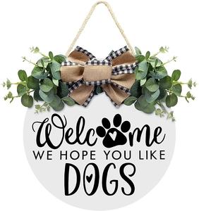 Detail of white wooden welcome sign with eucalyptus leaves and dog paw print pattern