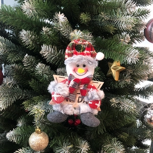 Detail of Christmas snowman ornament with Happy Day sign on a festive tree branch