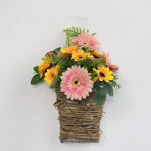 Detail of wall-hanging wicker basket with vibrant pink gerberas and yellow daisies