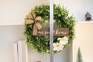 Eucalyptus wreath detail with wooden home sweet home sign and white daisies decor
