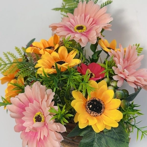 Detailed close-up of colorful artificial gerbera daisies in a brown woven basket