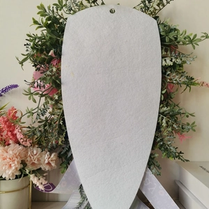 Back view of artificial floral wreath with white felt base and purple hanging ribbons
