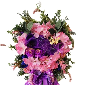 Handmade artificial wreath with pink hydrangea, purple roses and decorative bow for home decor